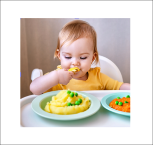 Ett barn i 6 månaders ålder sitter vid ett bort och får smaka på smakportioner av mosad potatis och mosade morötter. AIG genererad bild via Adobe Express.